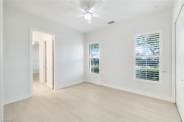 Unfurnished bedroom with ceiling fan, light wood-style floors, and a closet