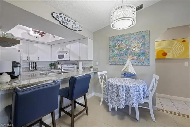 Dining room featuring a textured ceiling, light tile patterned flooring, and ceiling fan