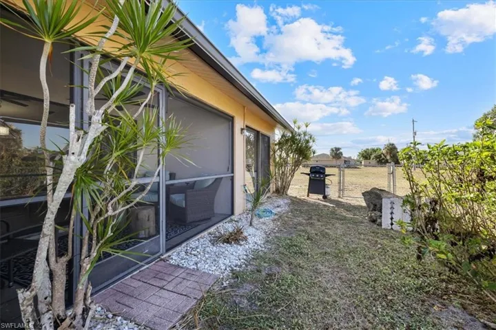 View of yard with a gate and a sunroom