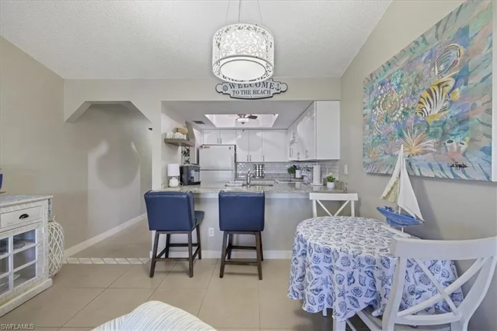 Dining area featuring light tile patterned floors and a textured ceiling