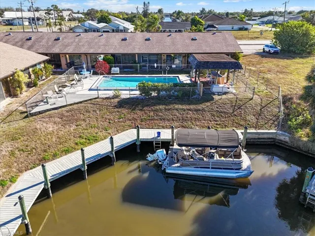 Back of property featuring a patio area, a community pool, and a residential view