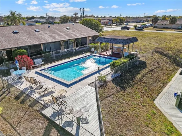 Community pool with a patio area, a pergola, and a residential view