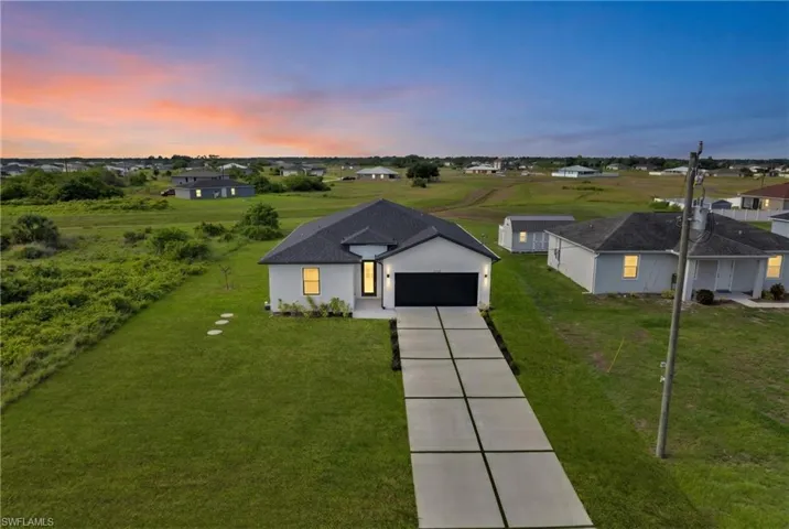 Contemporary single-story residence featuring a dark shingle roof and a two-car garage