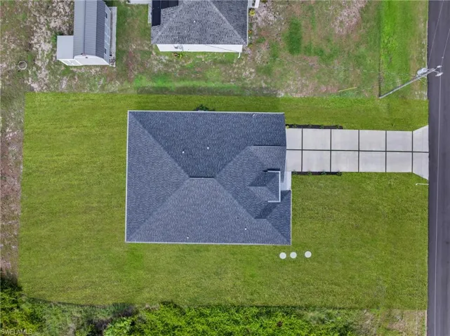 New construction home featuring a dark shingle roof and a concrete driveway