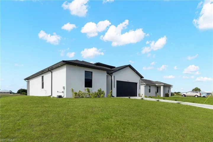 Modern contemporary exterior featuring a dark asphalt shingle roof, white stucco siding, and a dark garage door