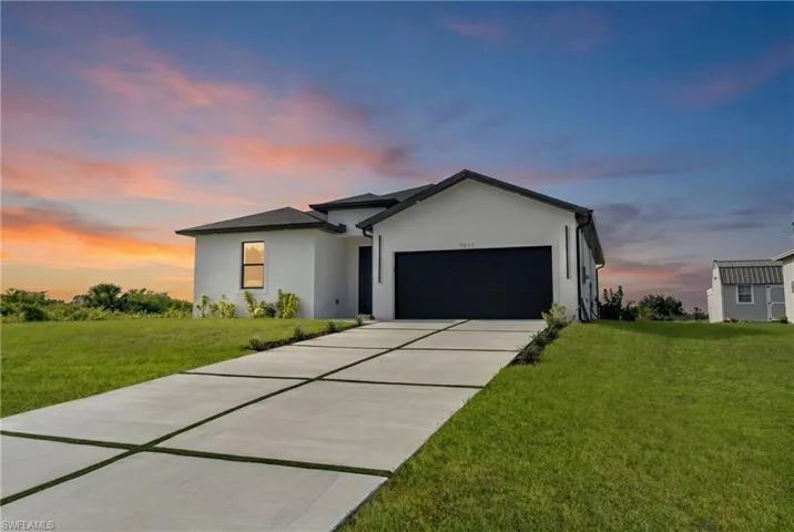 Modern single-story residence with a white stucco exterior and black trim accents