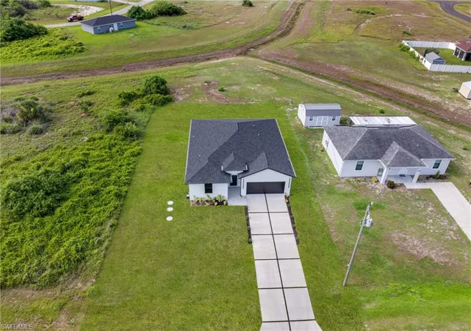 Modern single-story residence featuring a dark shingle roof and a concrete driveway