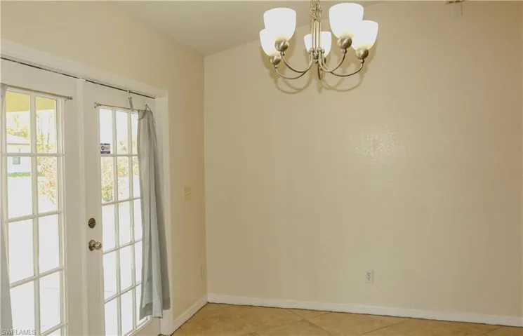 Doorway to outside featuring hanging lights, french doors, and tile patterned flooring
