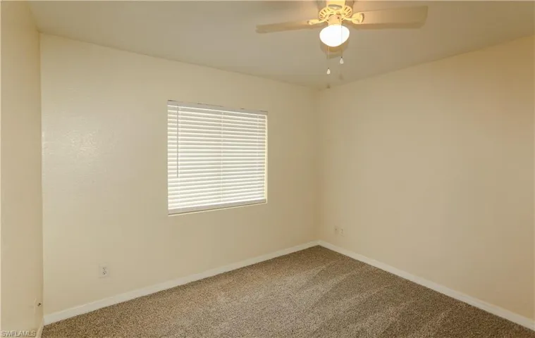 Empty room featuring light carpet and ceiling fan