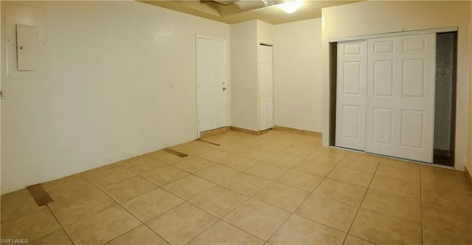 Bonus Room with closet with electric panel, light tile patterned flooring, and a closet