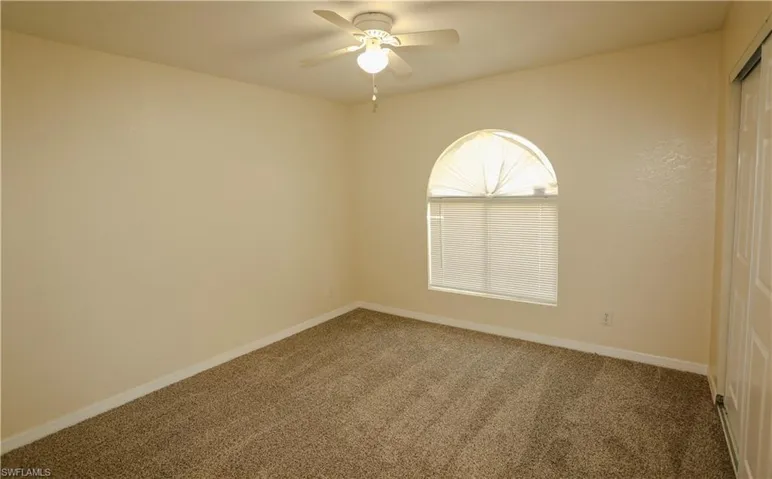 Unfurnished room featuring carpet floors and a ceiling fan