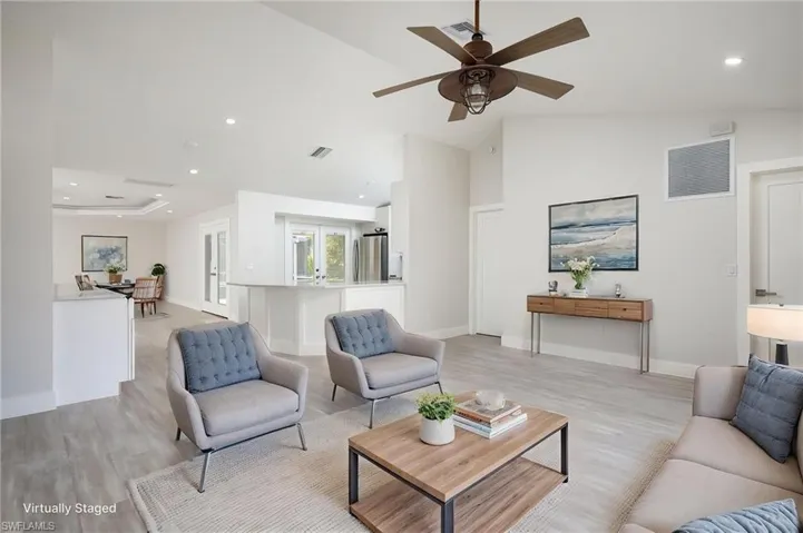 Spacious living area featuring light-toned flooring and recessed lighting.
