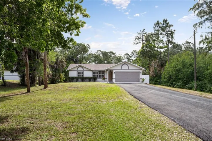 This property features a well-maintained lawn, a paved driveway, and updated landscaping.
