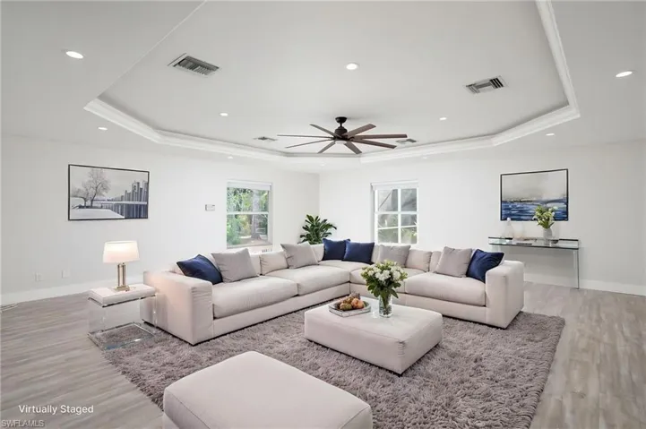 The expansive family room features recessed lighting, a ceiling fan, and crown molding