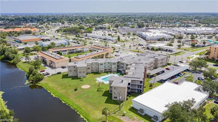 Aerial view of a nearby body of water and apartment complex / building