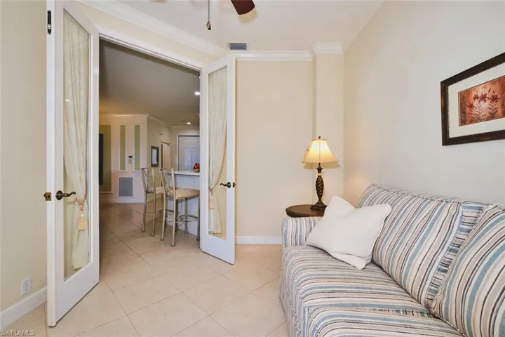 Living room with crown molding, french doors, light tile patterned floors, and a ceiling fan