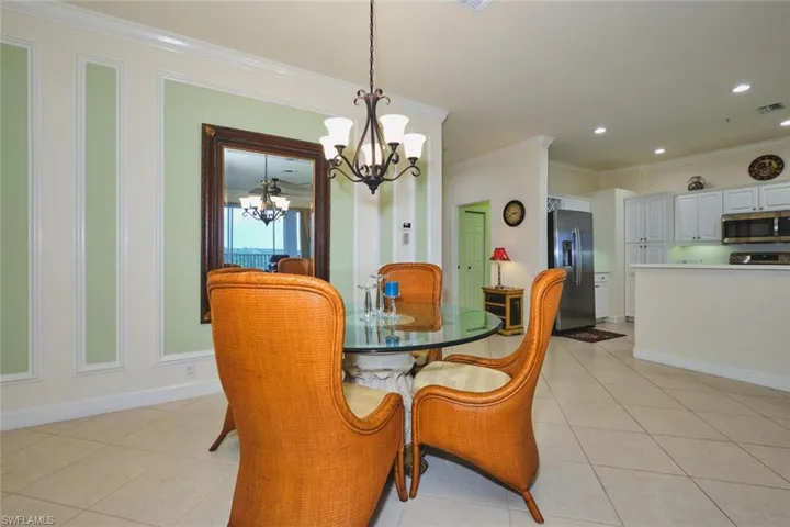 Dining space featuring light tile patterned flooring, crown molding, a chandelier, and recessed lighting