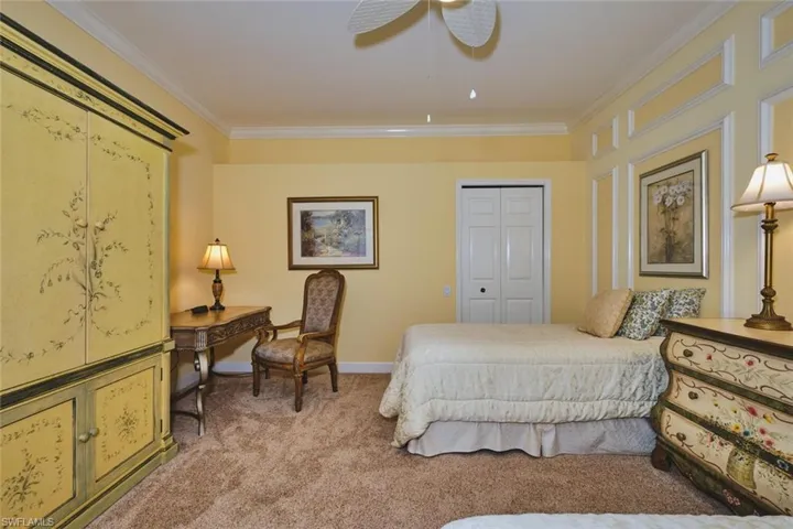 Bedroom featuring ornamental molding, light carpet, a closet, and ceiling fan