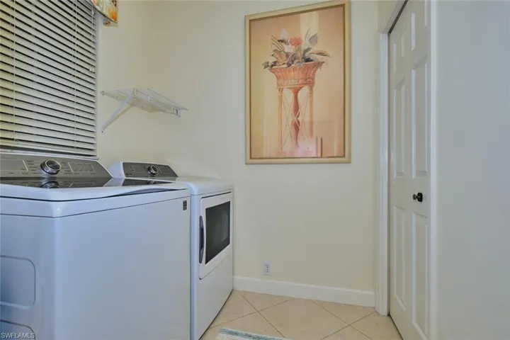 Laundry room featuring light tile patterned floors and washing machine and dryer