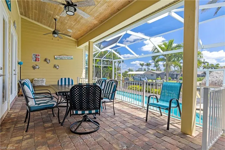View of patio, pool, a lanai, ceiling fan, and outdoor dining area