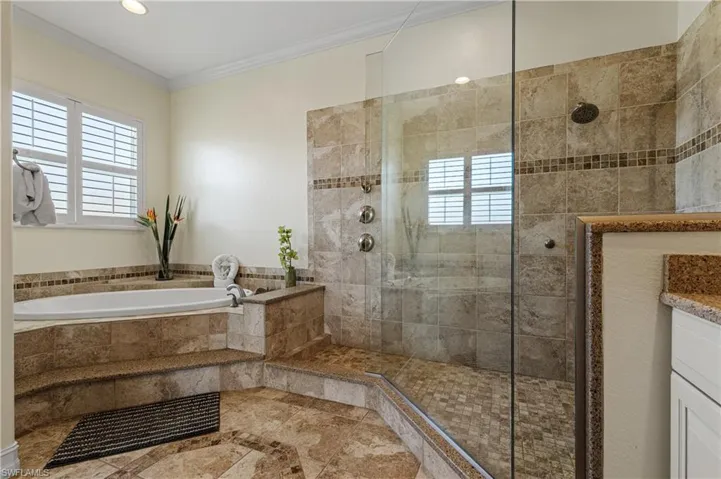 A wealth of natural light, walk in shower, separate tub, crown molding