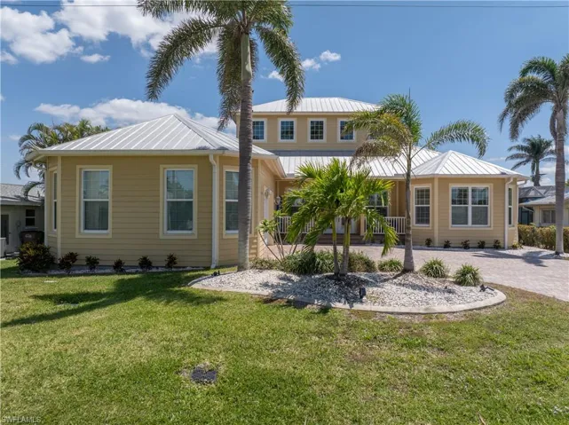 View of front of home featuring driveway and metal roof