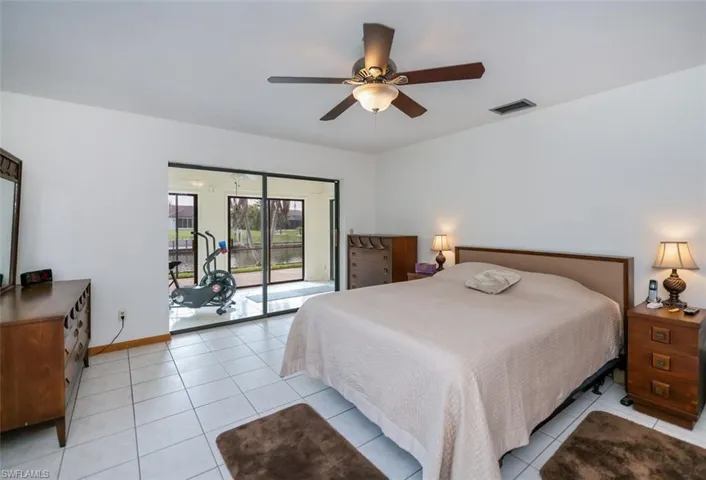 Bedroom with access to exterior, light tile patterned flooring, and a ceiling fan