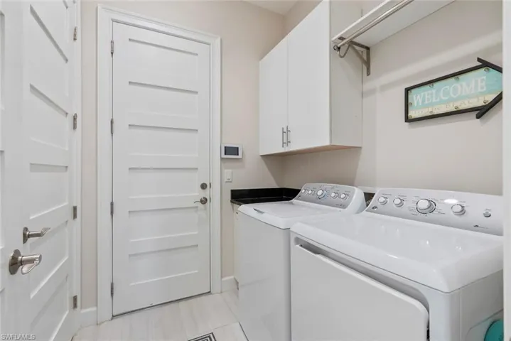 Laundry area featuring washer and dryer and cabinet space