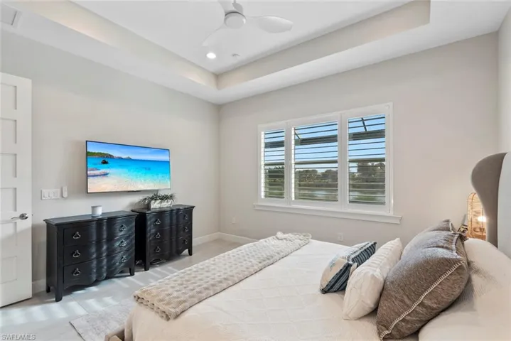 Primary Bedroom featuring a tray ceiling, ceiling fan, and recessed lighting
