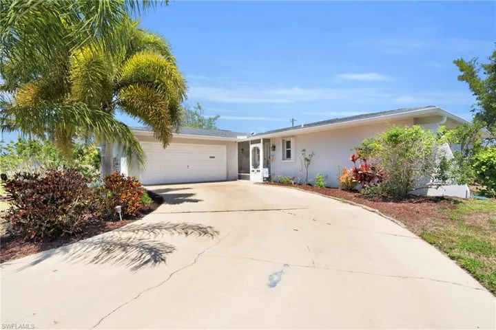 Single story home with a garage, driveway, and stucco siding