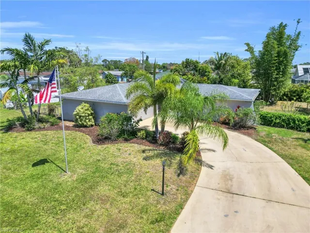 View of front of home with concrete driveway, stucco siding, and a front lawn