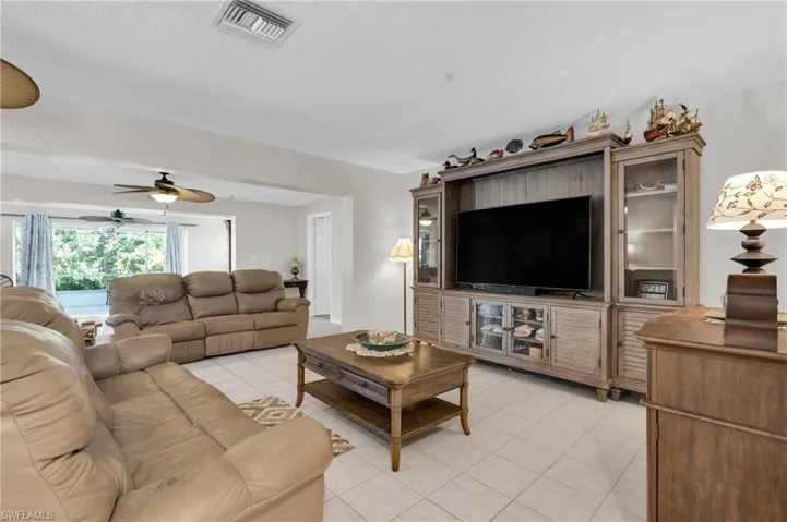 Living room featuring visible vents and a ceiling fan