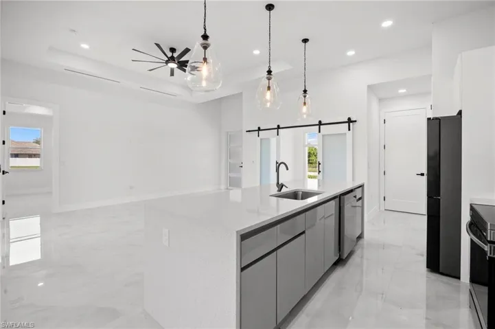 Modern kitchen island with a quartz countertop, integrated sink, and sleek grey cabinetry