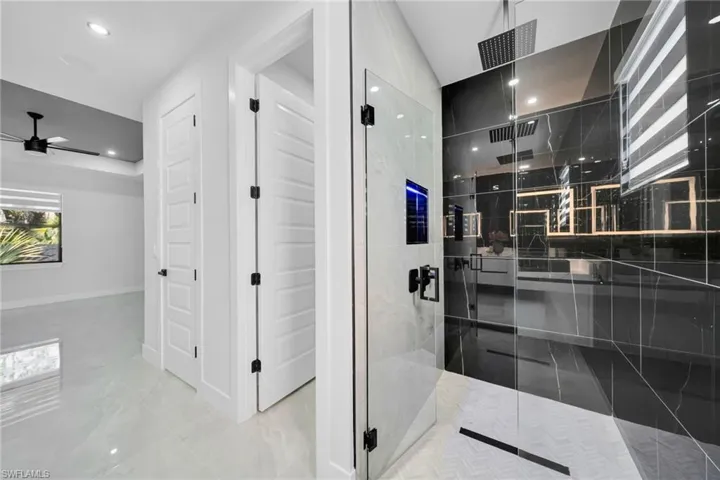 Full bathroom with a marble finish shower and recessed lighting