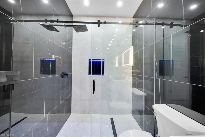 Full bathroom featuring toilet and a stall shower