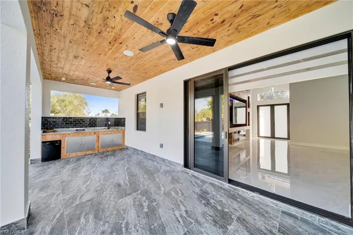 View of patio with area for grilling and a ceiling fan