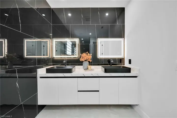 Full bath featuring double vanity and baseboards