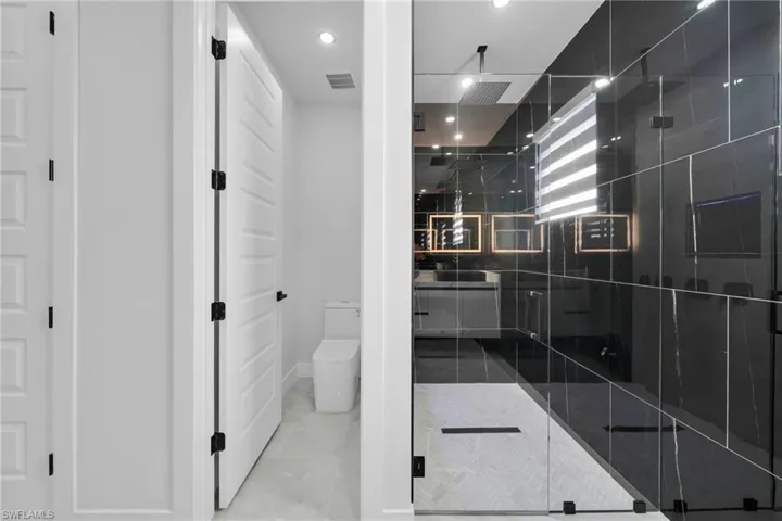 Full bath with vanity, a shower stall, recessed lighting, and light tile patterned floors