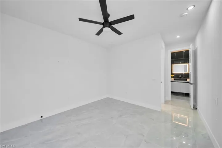 Unfurnished bedroom with ceiling fan, recessed lighting, and light marble finish flooring