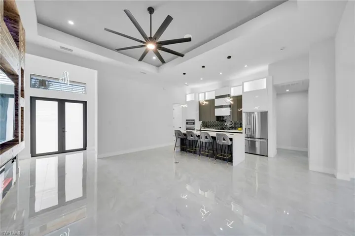 Living room with a ceiling fan, recessed lighting, and french doors