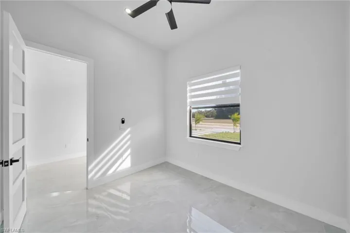 Spare room with baseboards and a ceiling fan