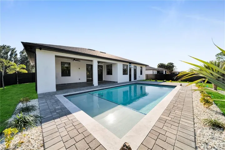 Rear view of house featuring ceiling fan, a fenced backyard, a patio area, and stucco siding