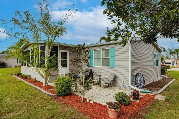 Back of house featuring a patio area, a sunroom, and a lawn