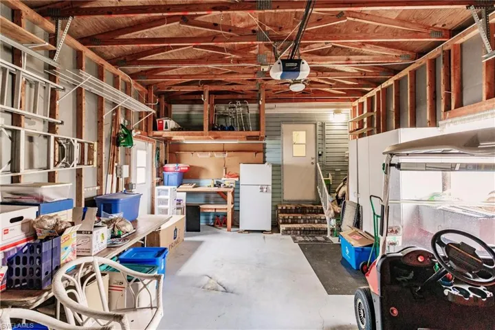 Garage featuring white fridge and a garage door opener