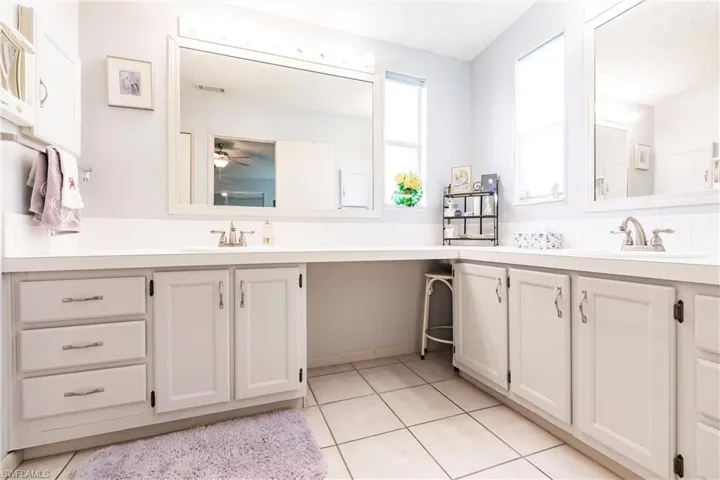 Bathroom featuring ceiling fan, vanity, and tile patterned flooring
