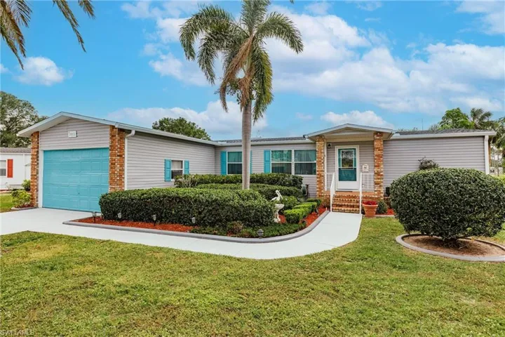Single story home featuring a front yard and a garage