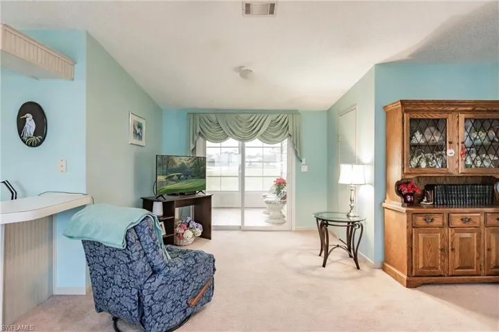 Sitting room featuring light colored carpet and a textured ceiling