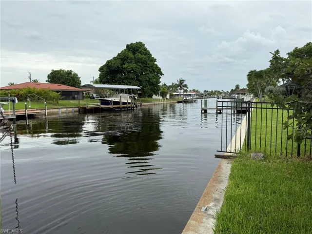 Dock area with a water view and a lawn