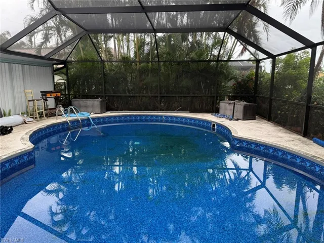Swimming pool with glass enclosure and a patio