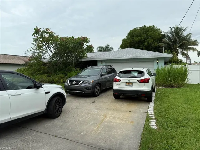 View of parking featuring concrete driveway